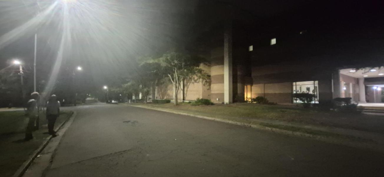 A very bright streetlight on Maryland Avenue glares across the street and lights the side of a school building at night